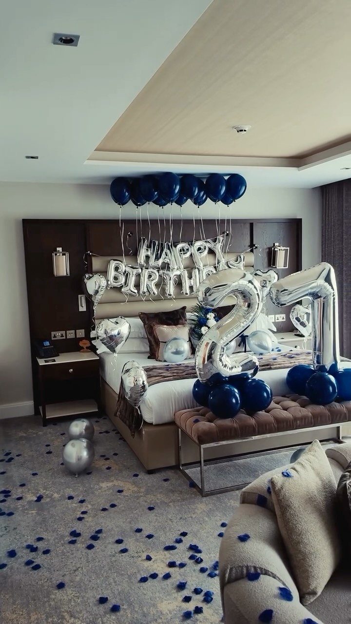 Hotel room decorated with blue and silver balloons and '21' for a birthday.