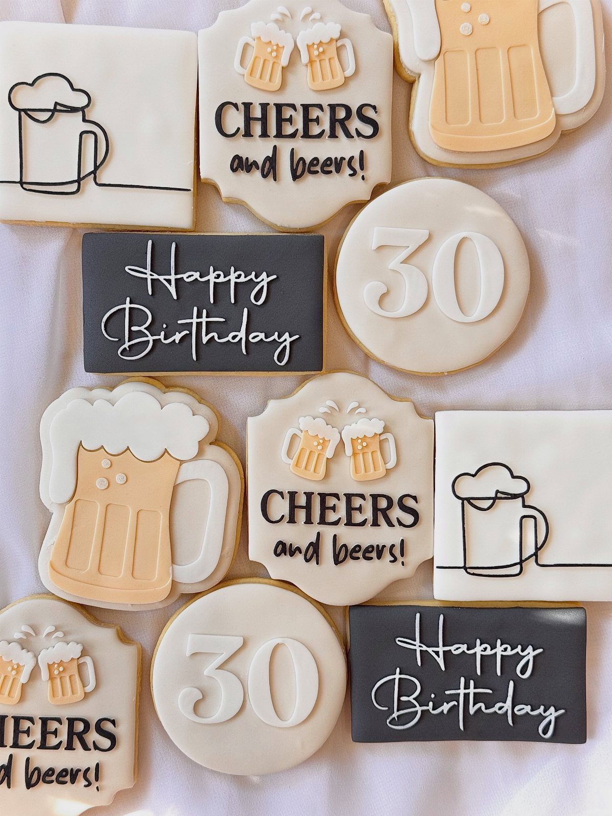 Decorated birthday cookies featuring beer mugs, the number 30, and celebratory messages.
