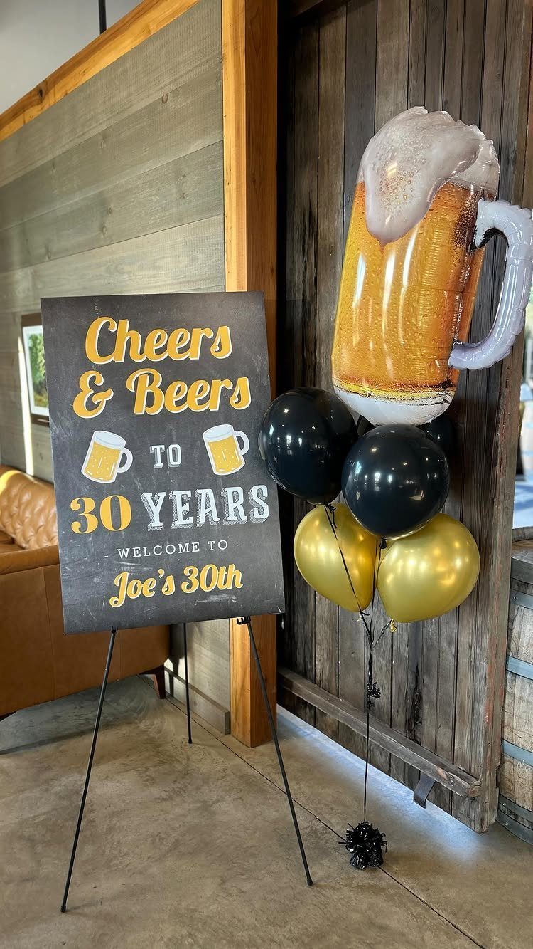 Chalkboard birthday sign and beer mug balloons for a 30th birthday celebration.