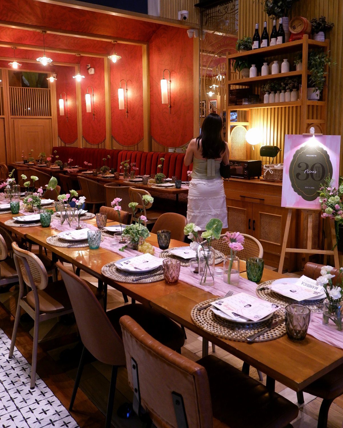 Long wooden dining table set for a 30th birthday party in a red restaurant
