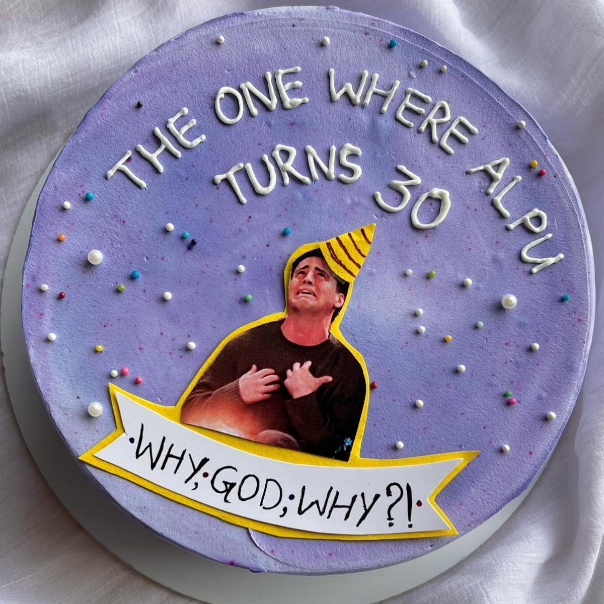 Purple birthday cake with white icing text and a funny printed character image.
