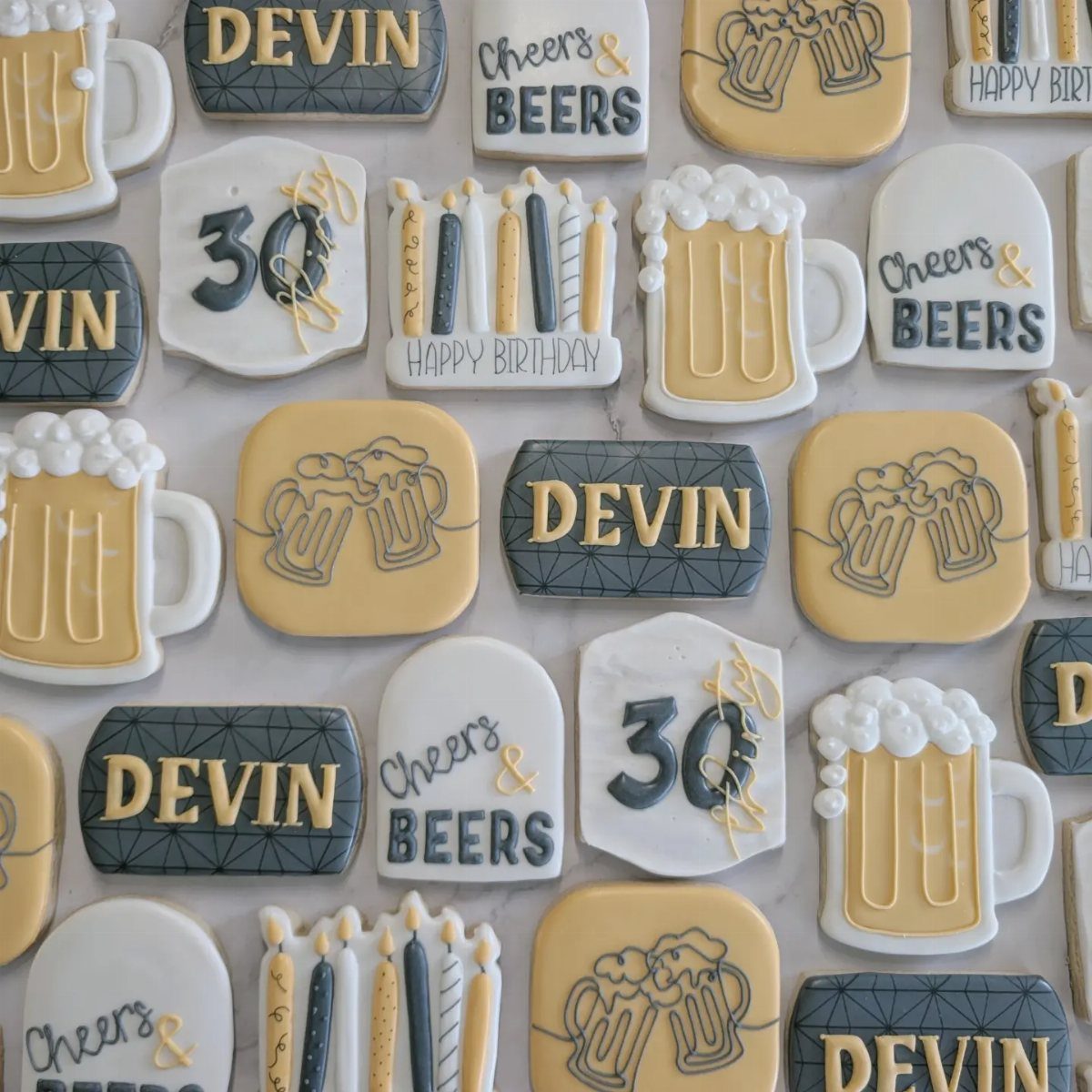 Decorated birthday cookies featuring beer mugs, the name Devin, and the number 30.