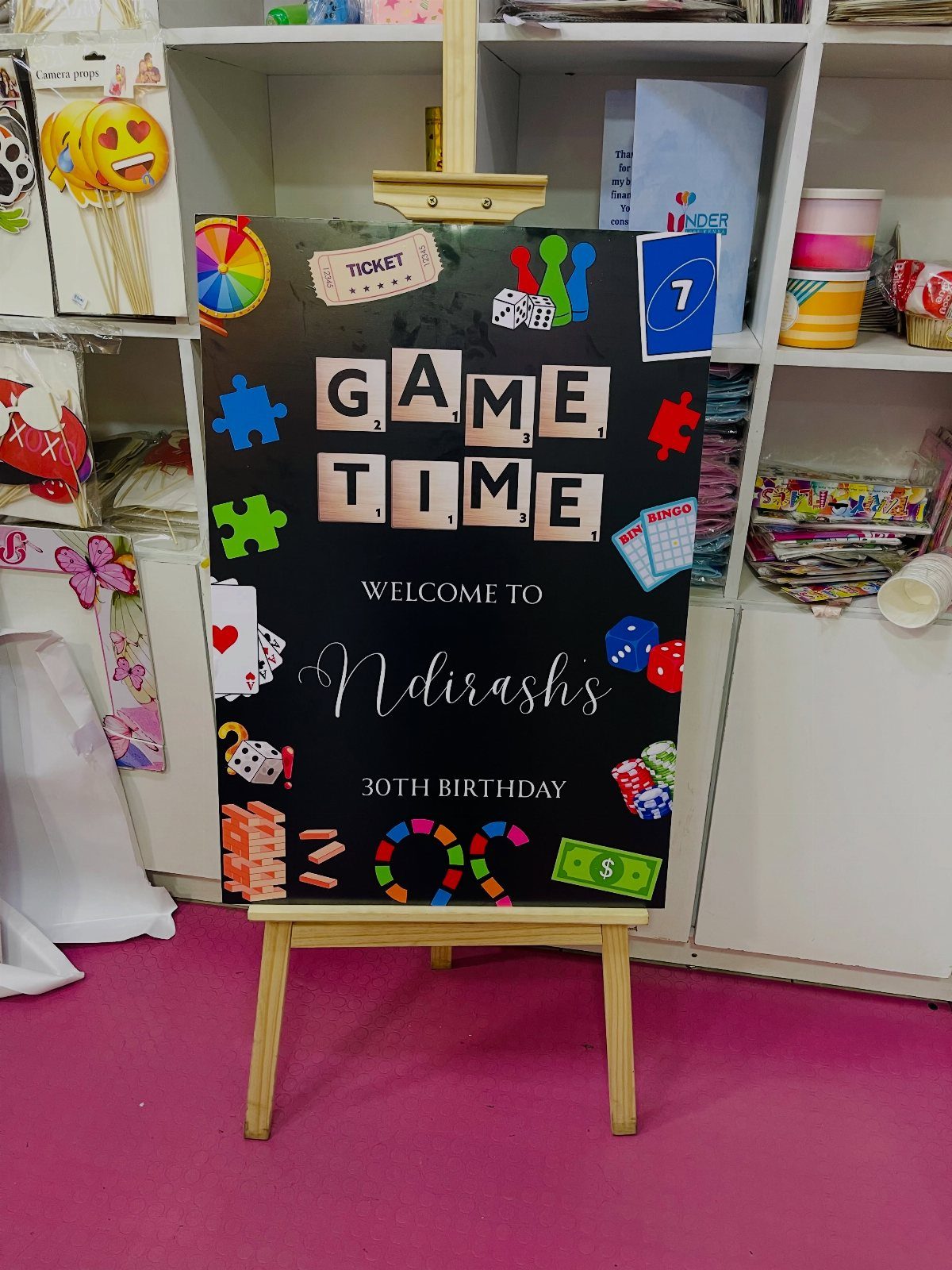 Game themed 30th birthday welcome sign on a wooden easel in a room
