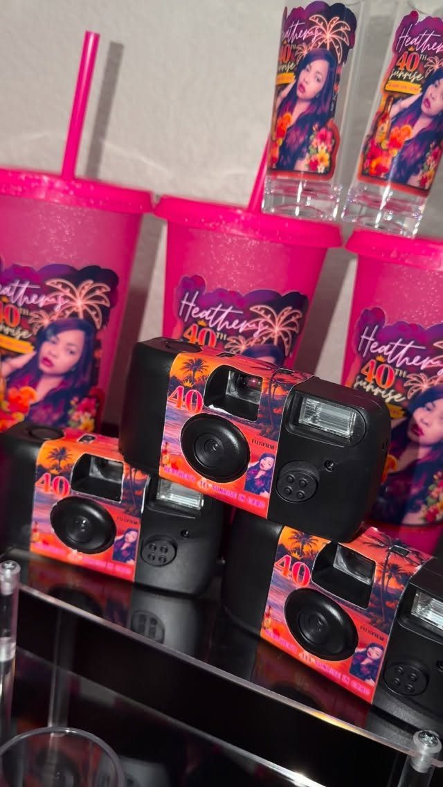 Customized disposable cameras and pink tumblers for a 40th birthday party celebration.