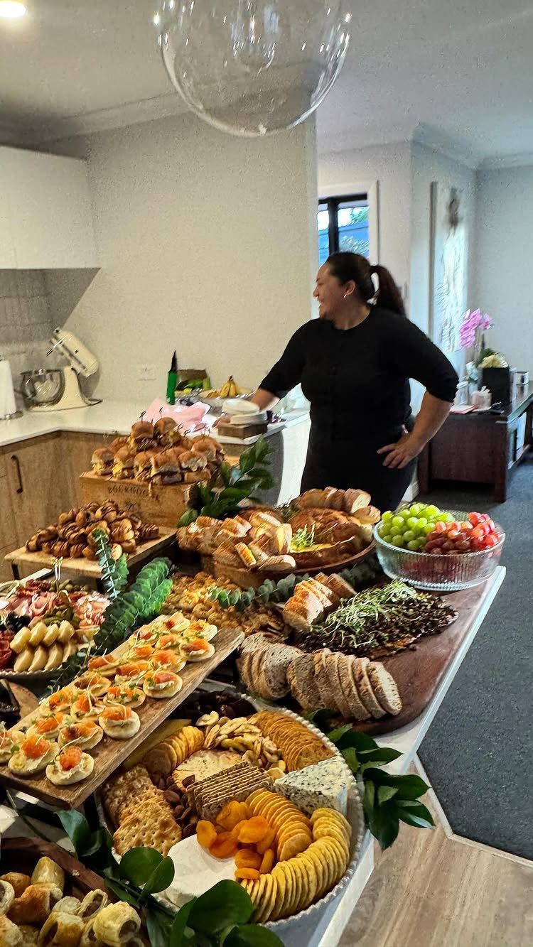 Gourmet grazing table with breads, cheeses, and fruits in a modern home setting.