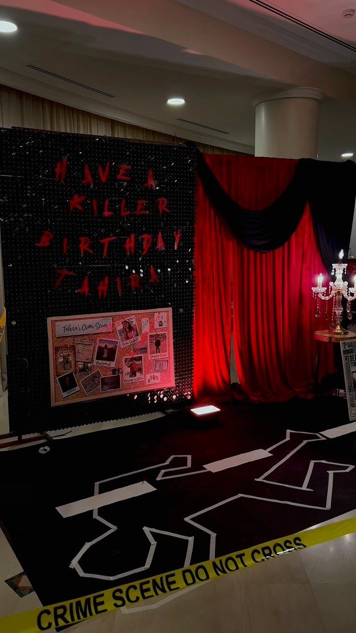 Crime scene themed birthday party setup with body outline and yellow caution tape.