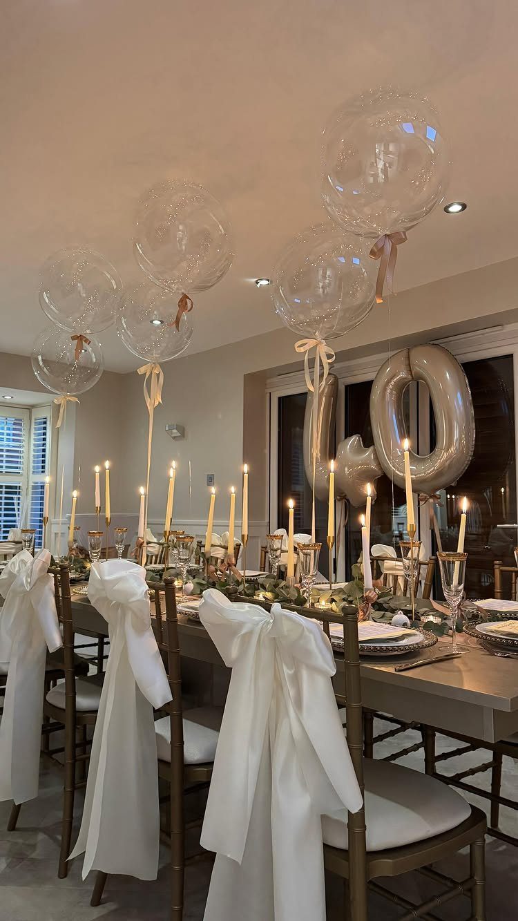 Elegant dinner table set for a 40th birthday with candles and silver balloons.