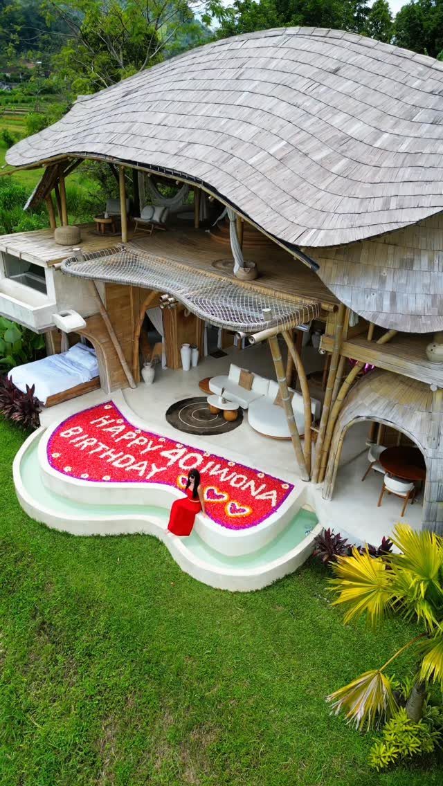 Woman lying next to a 40th birthday flower petal message at a bamboo villa