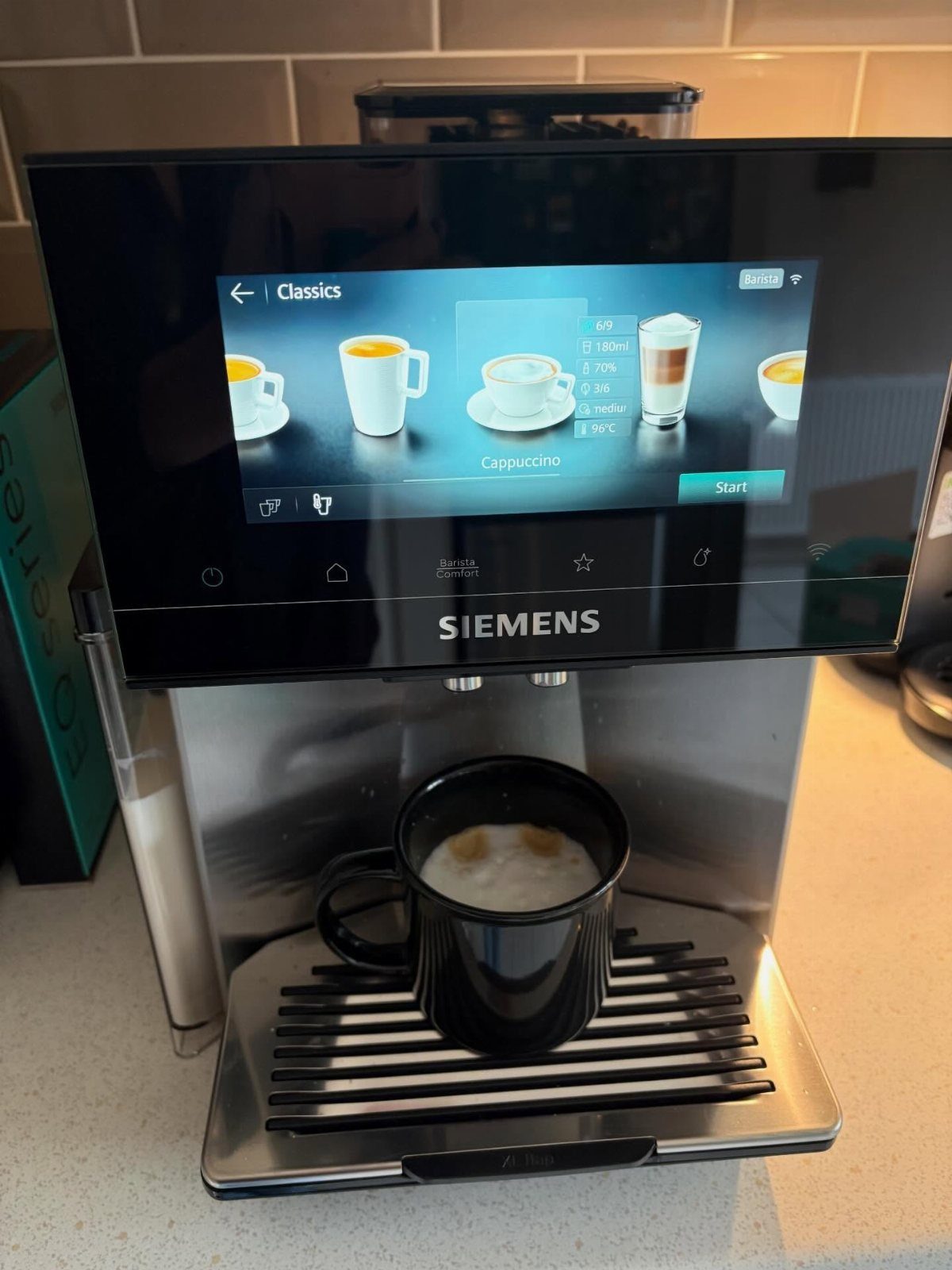 Siemens espresso machine with a digital screen and a black mug of coffee.