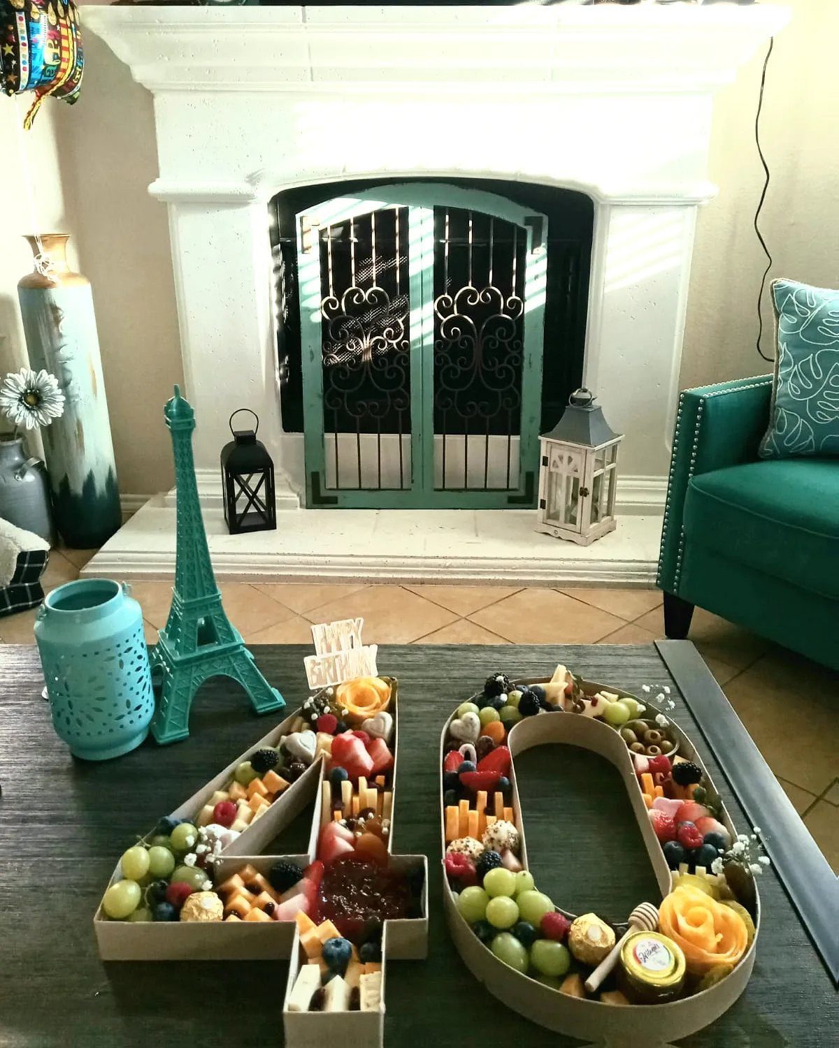 Charcuterie board shaped like the number 40 filled with fruit and cheese.