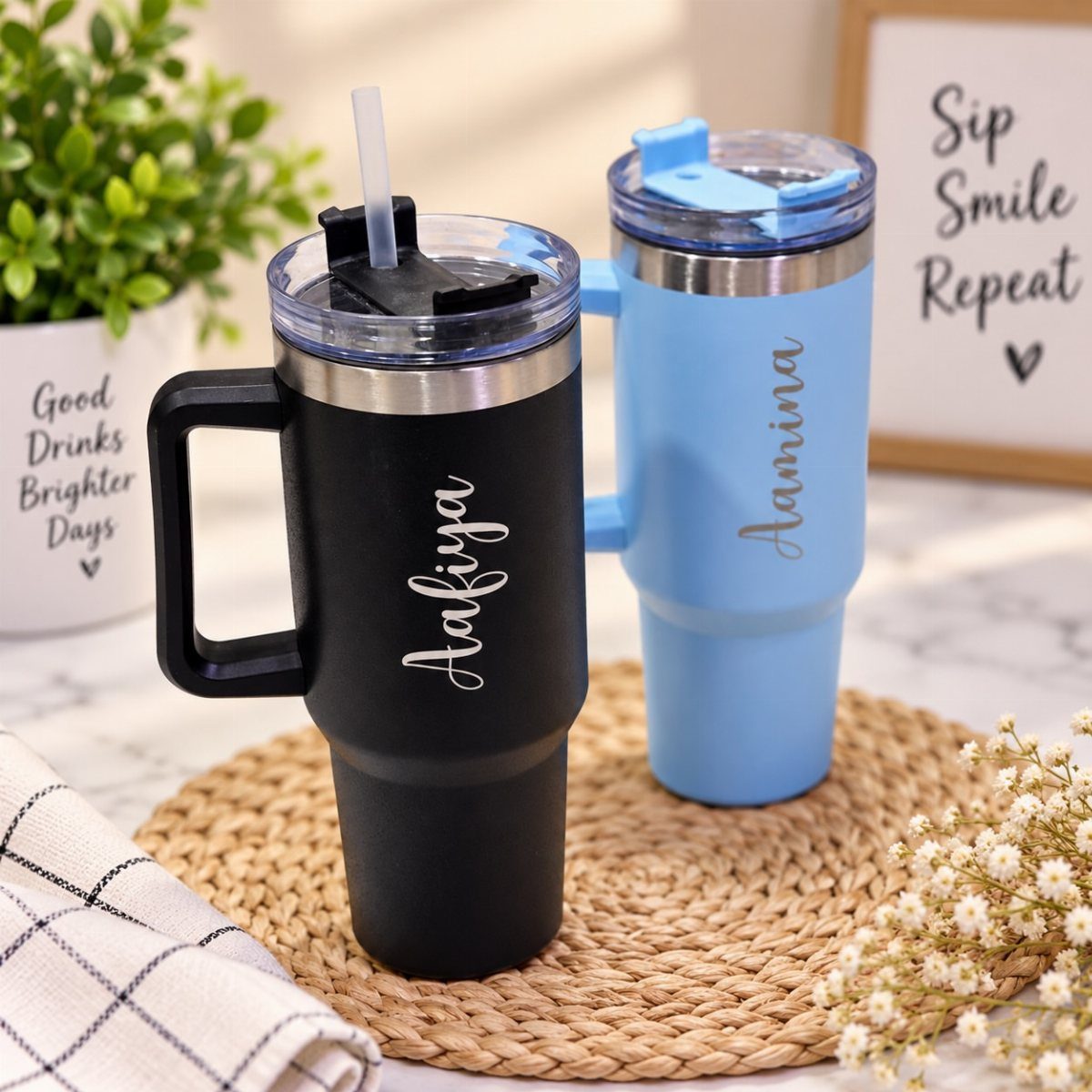Two personalized stainless steel tumblers in black and blue with engraved names on them.