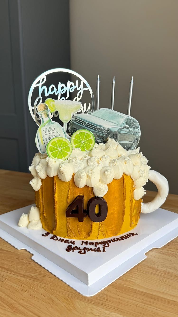 Beer mug shaped cake with number 40, car, and cocktail decorations.