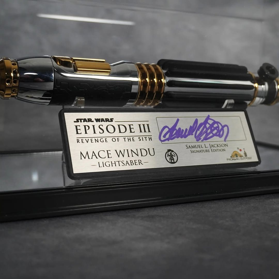 Mace Windu lightsaber replica on a display stand with a signature plaque.