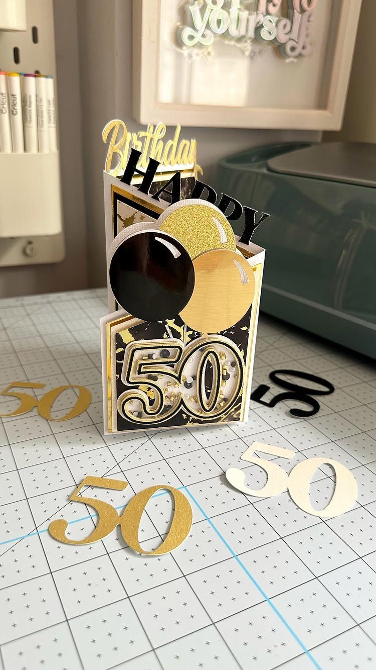 Handmade 50th birthday card with gold and black balloons and birthday toppers.