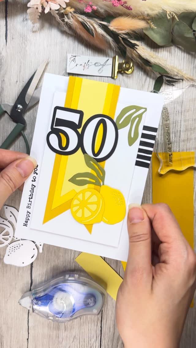 Handmade birthday card with bold 50 and lemons on a wooden craft table