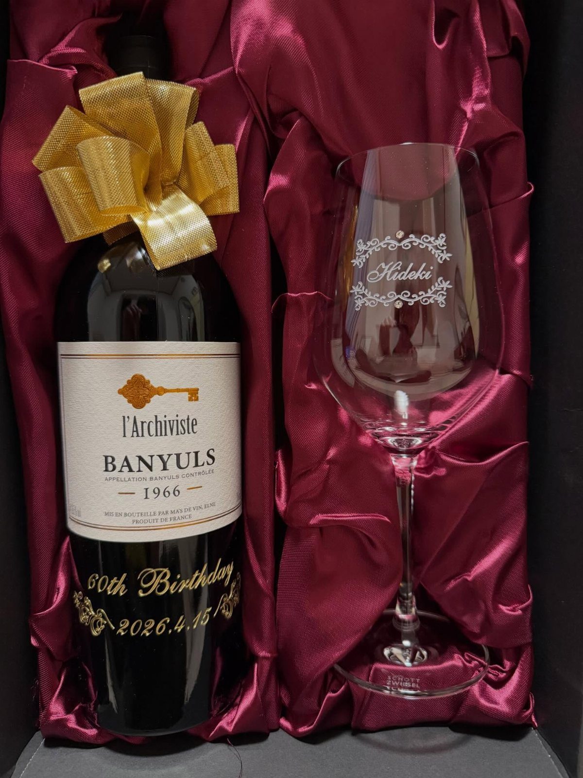 Bottle of 1966 vintage wine and engraved glass in red satin gift box