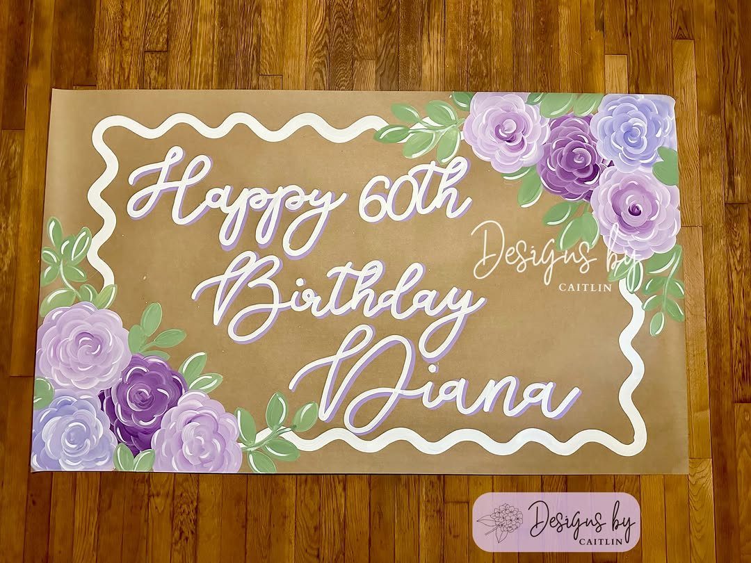 Brown birthday sign for Diana's 60th birthday with purple roses and white lettering.