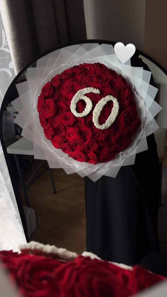 Circular red rose bouquet with white number 60 reflected in a mirror