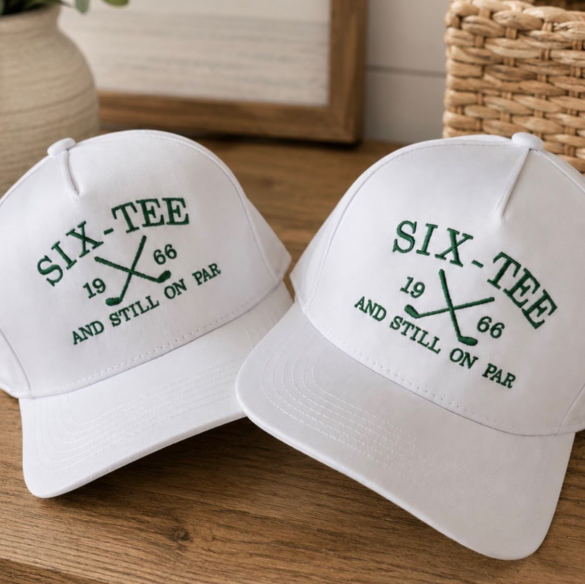 Two white baseball caps with green golf-themed embroidery for a 60th birthday.