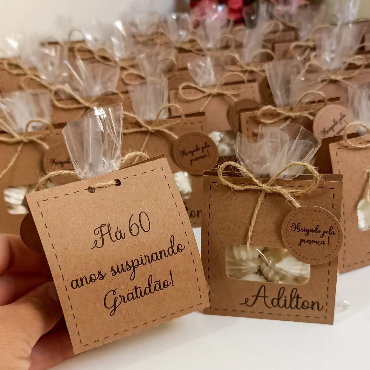 Brown kraft paper gift boxes containing white sweets for a 60th birthday celebration.