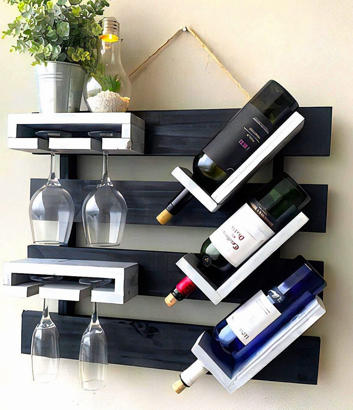 Wall-mounted black and white wooden wine rack holding bottles and glasses.