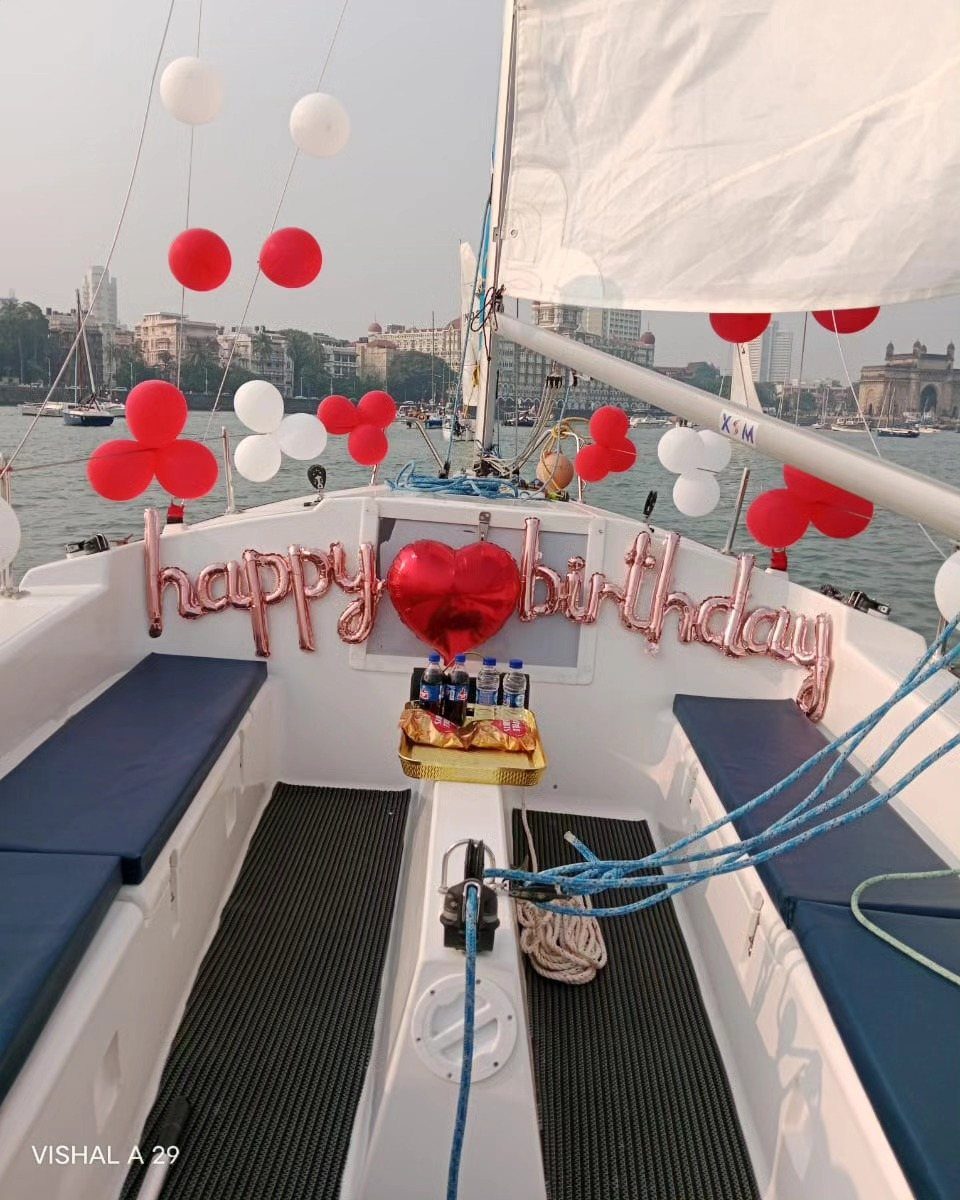 Sailboat deck decorated with red and white balloons and happy birthday lettering.