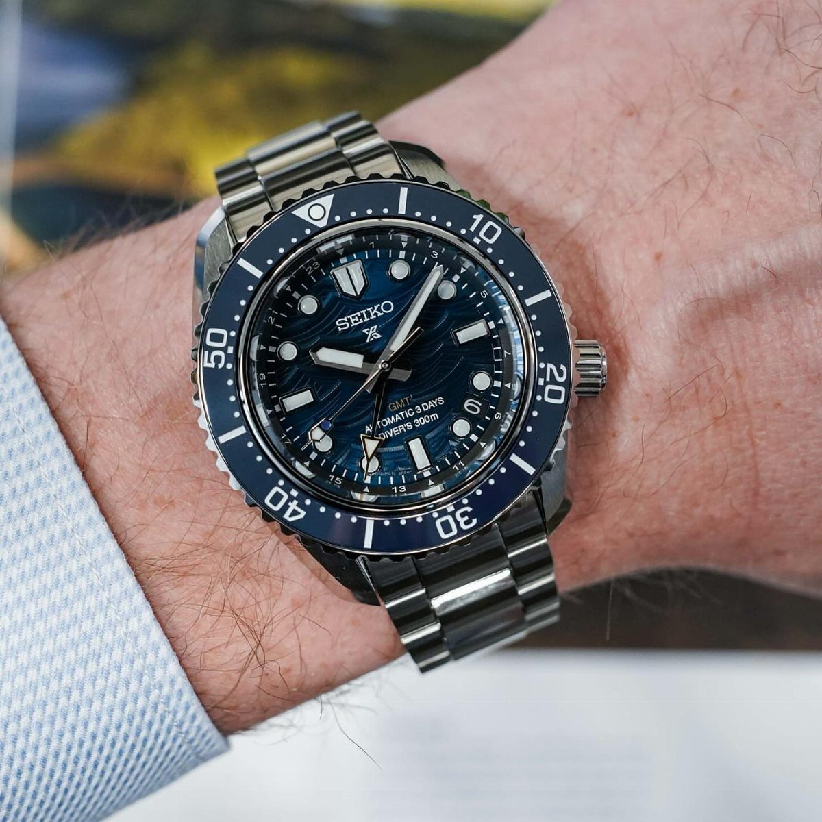 Silver Seiko dive watch with blue face on a man's wrist