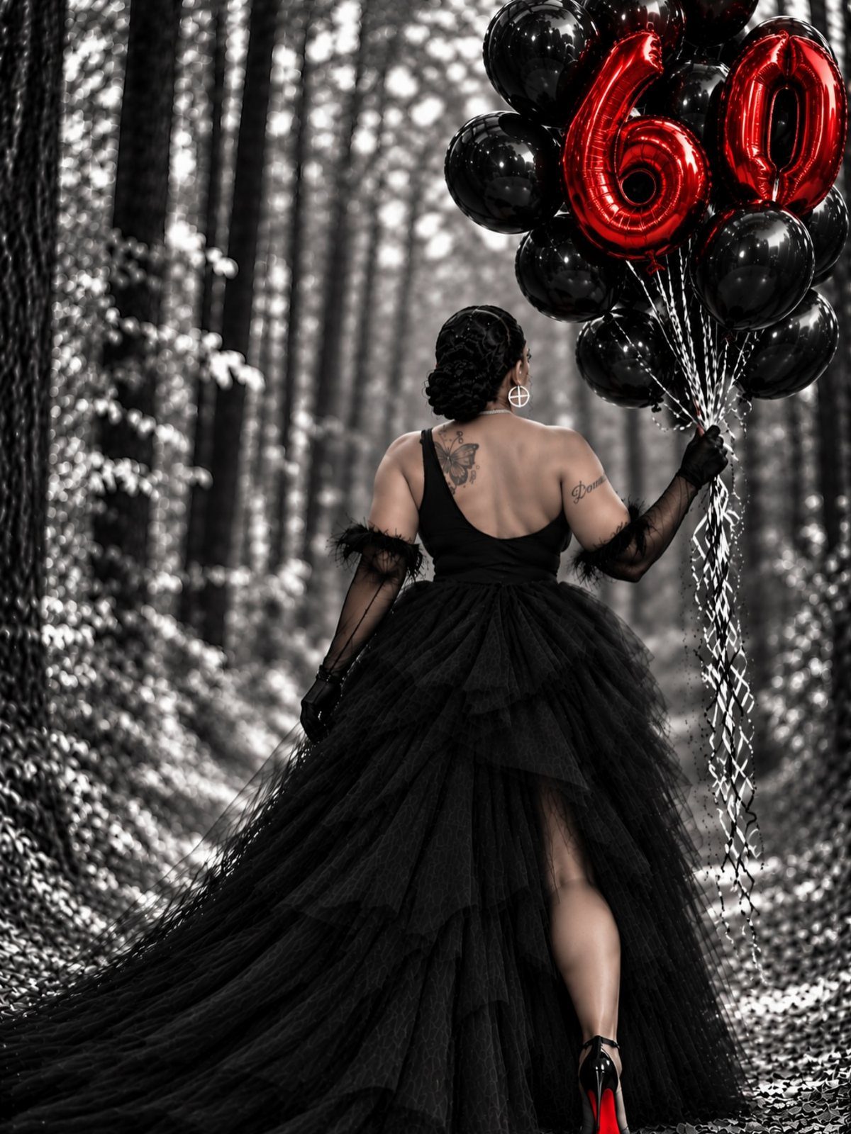 Woman in black gown holding red 60 balloons in a monochrome forest.