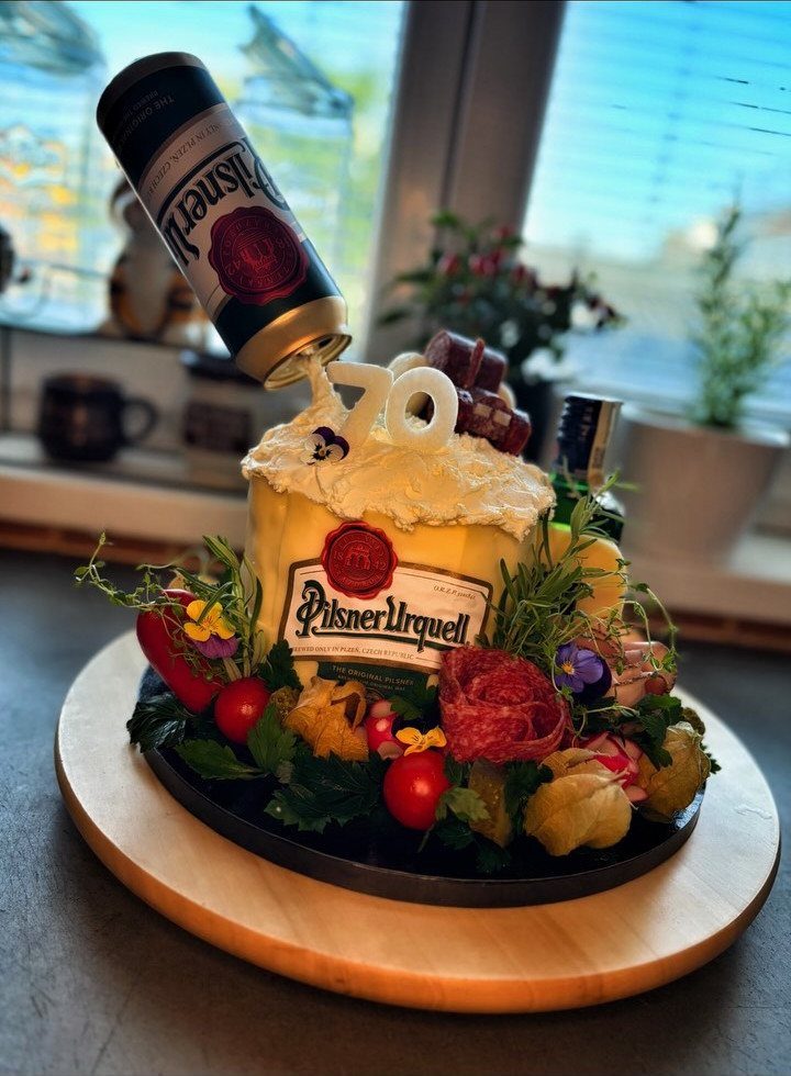Beer themed birthday cake with number 70 candles and a pouring beer can
