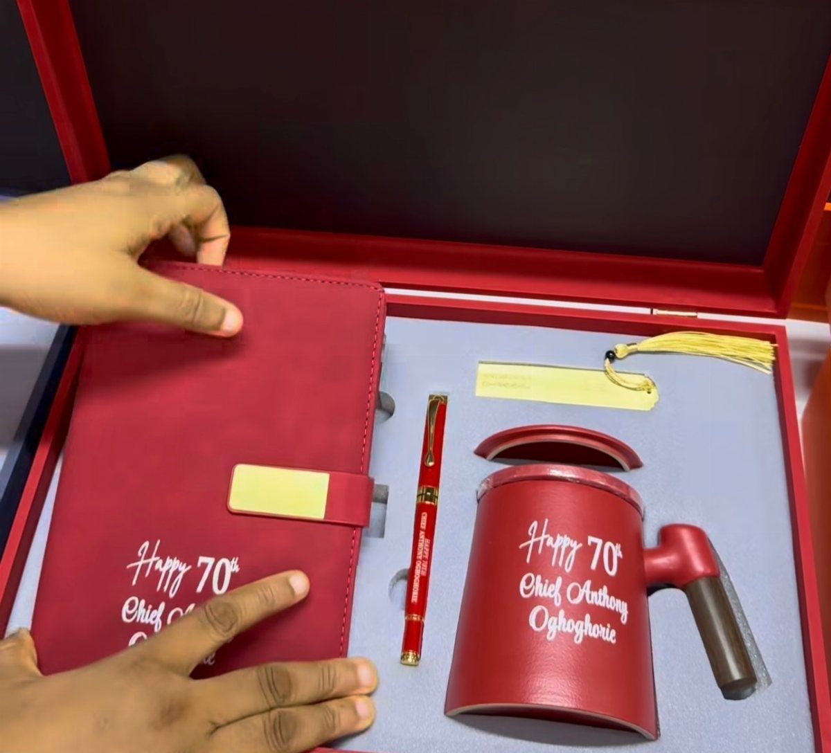 Red 70th birthday gift set with notebook, pen, and mug in a box.