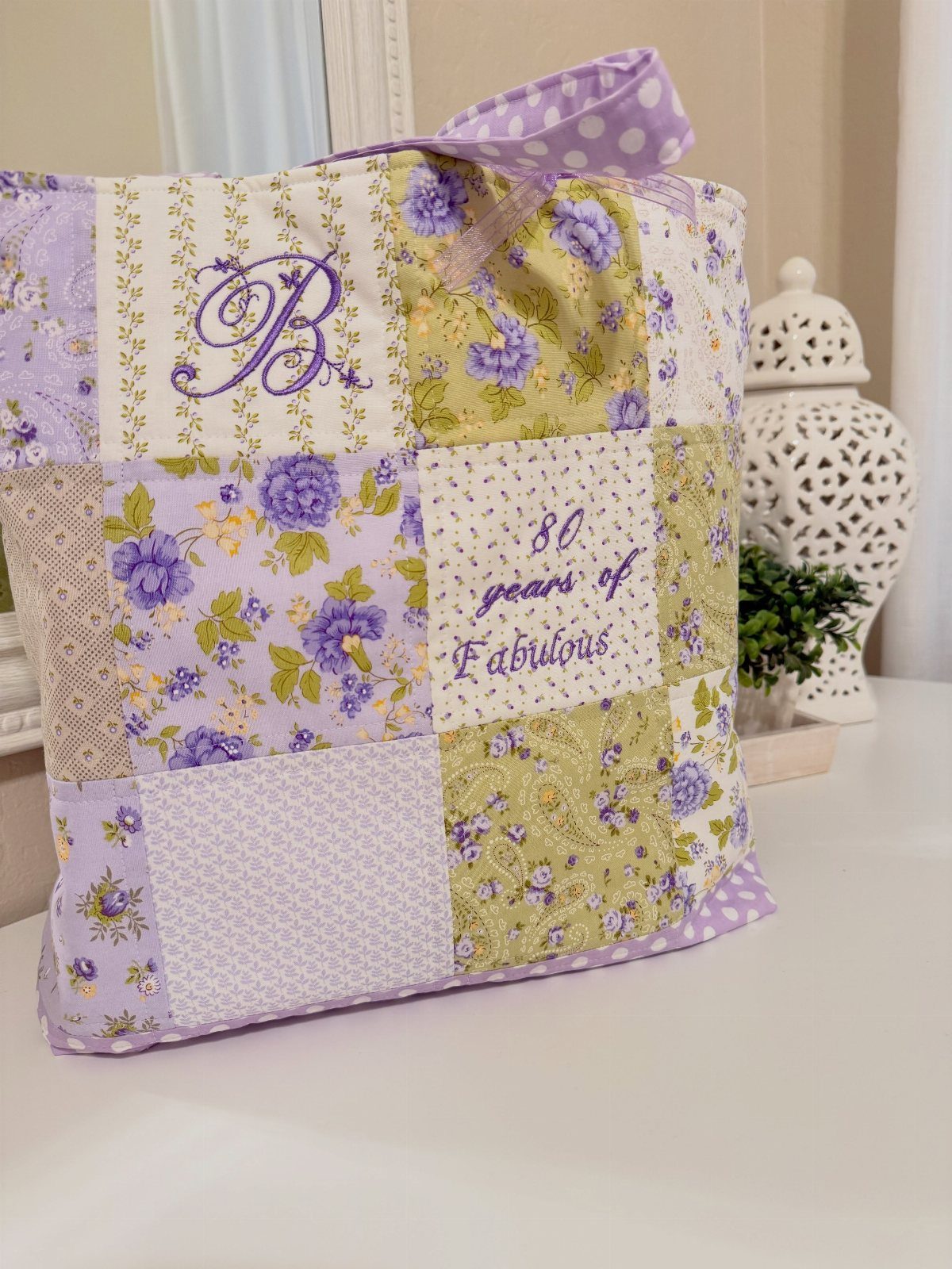 Patchwork fabric bag with purple floral patterns and 80th birthday embroidery.