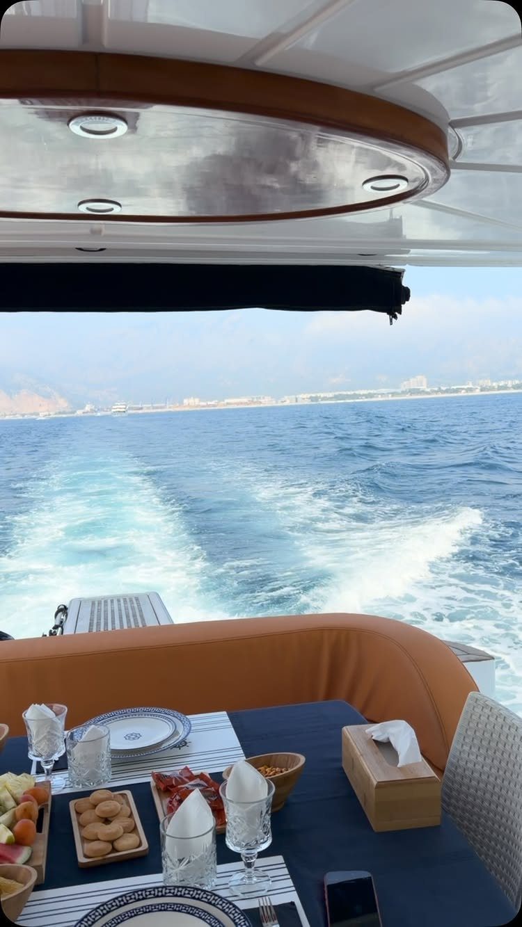 Luxury boat deck with a set dining table overlooking a blue ocean wake