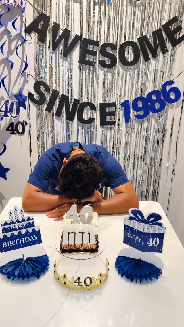 Man leaning over a 40th birthday cake with an awesome since 1986 backdrop