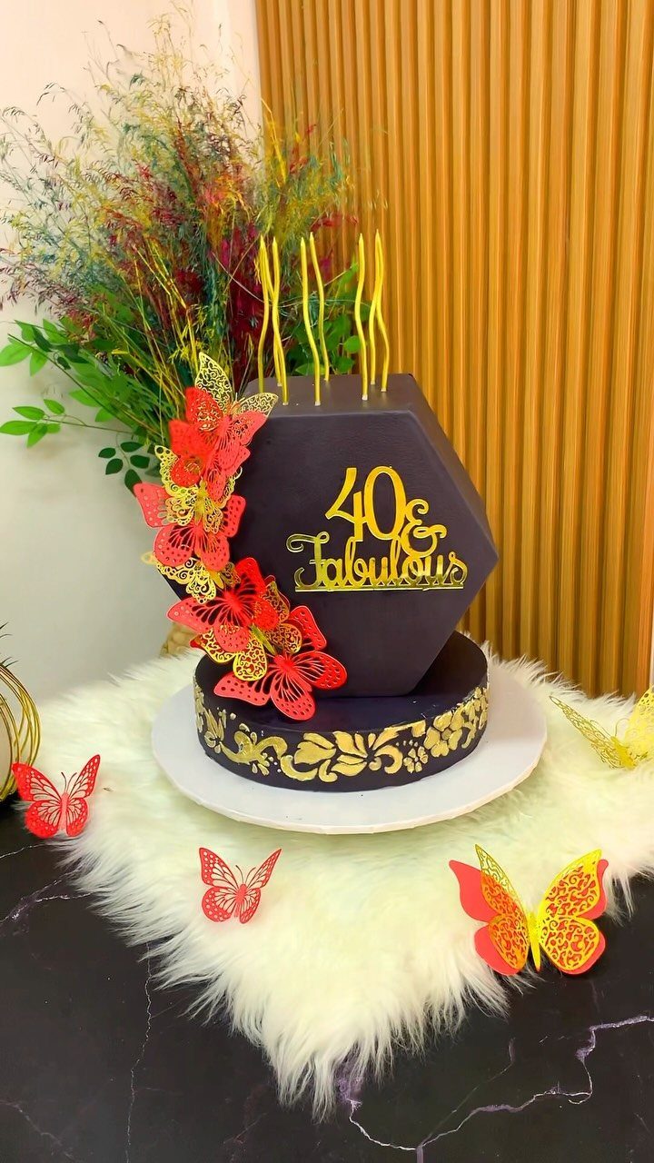 Dark purple 40th birthday cake with gold lettering and red butterfly decorations