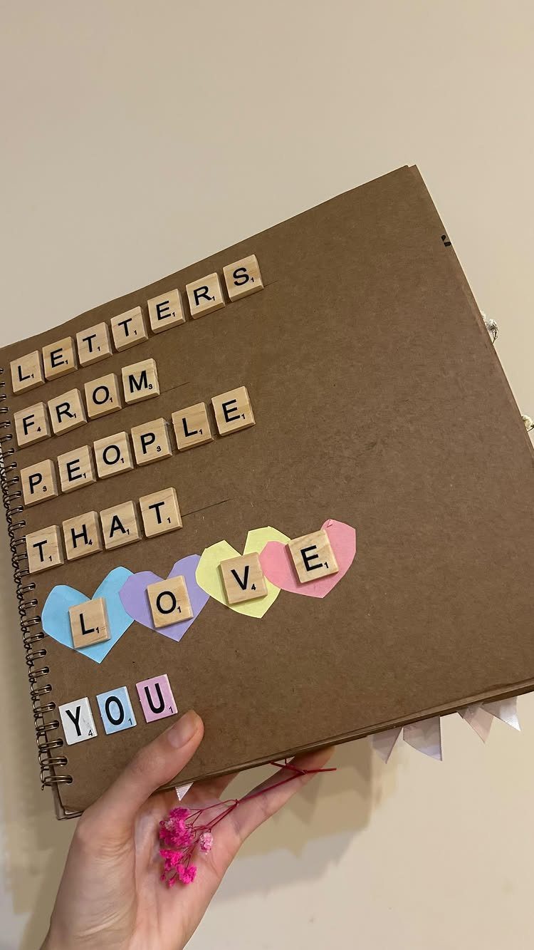 Brown scrapbook cover with wooden tiles spelling letters from people that love you
