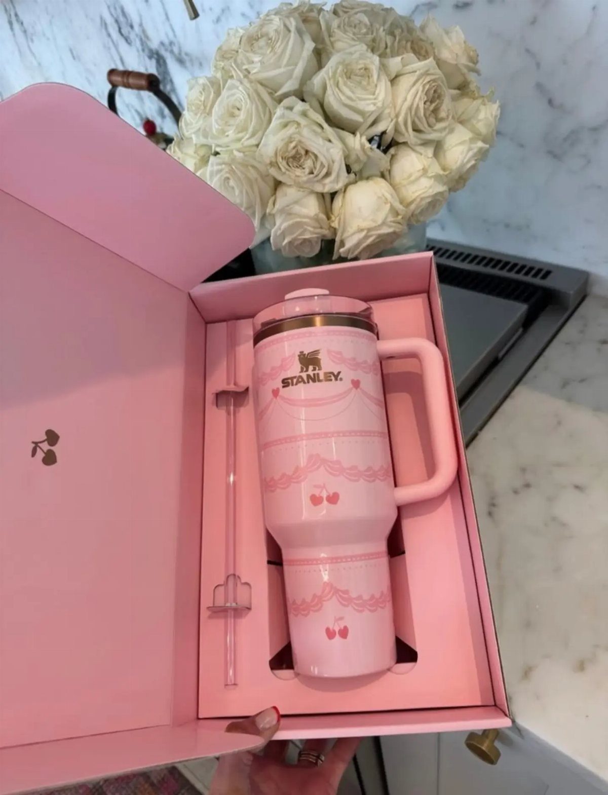 Pink Stanley tumbler with cherry patterns in a pink gift box with white roses.