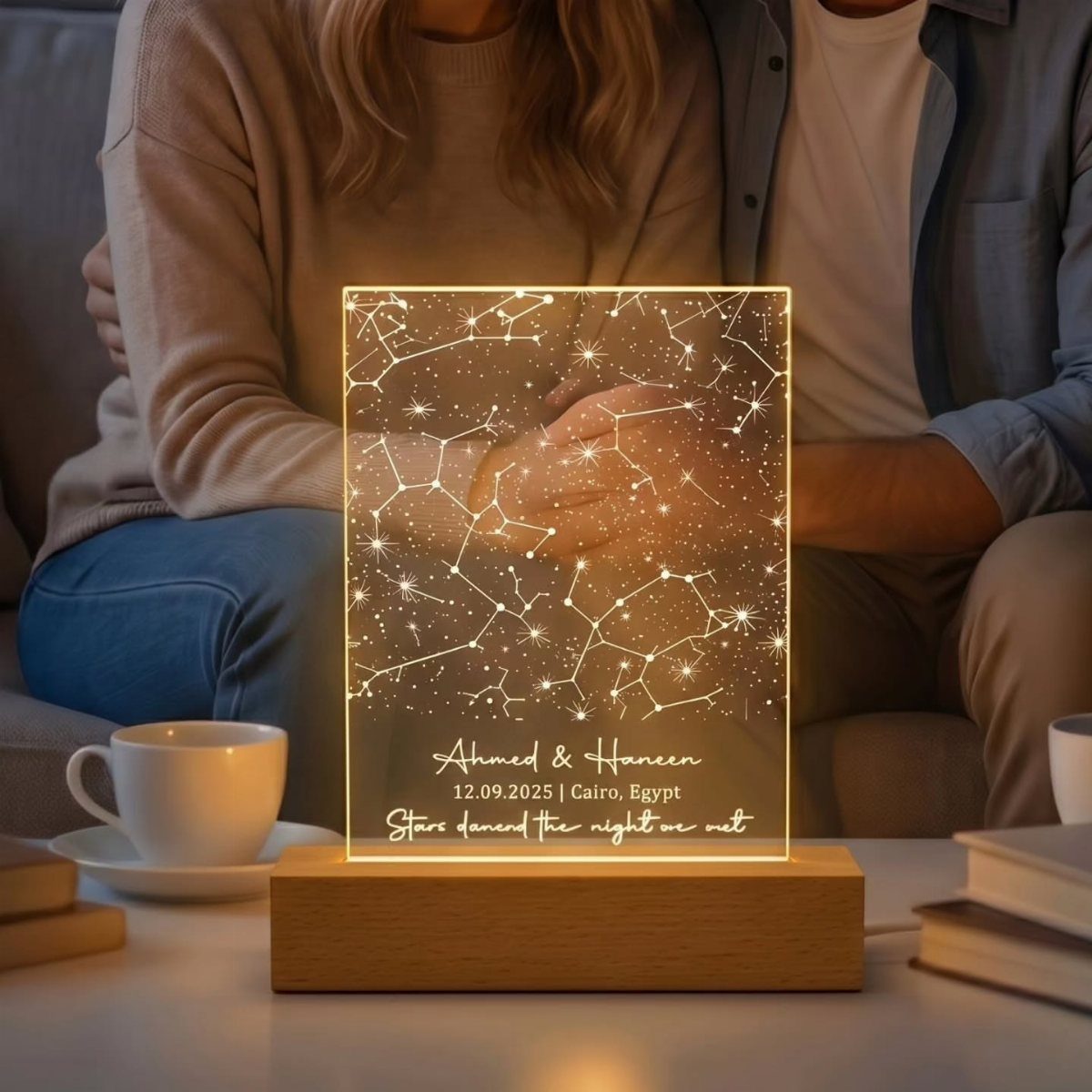 Illuminated acrylic star map plaque with personalized names and date on wooden base.