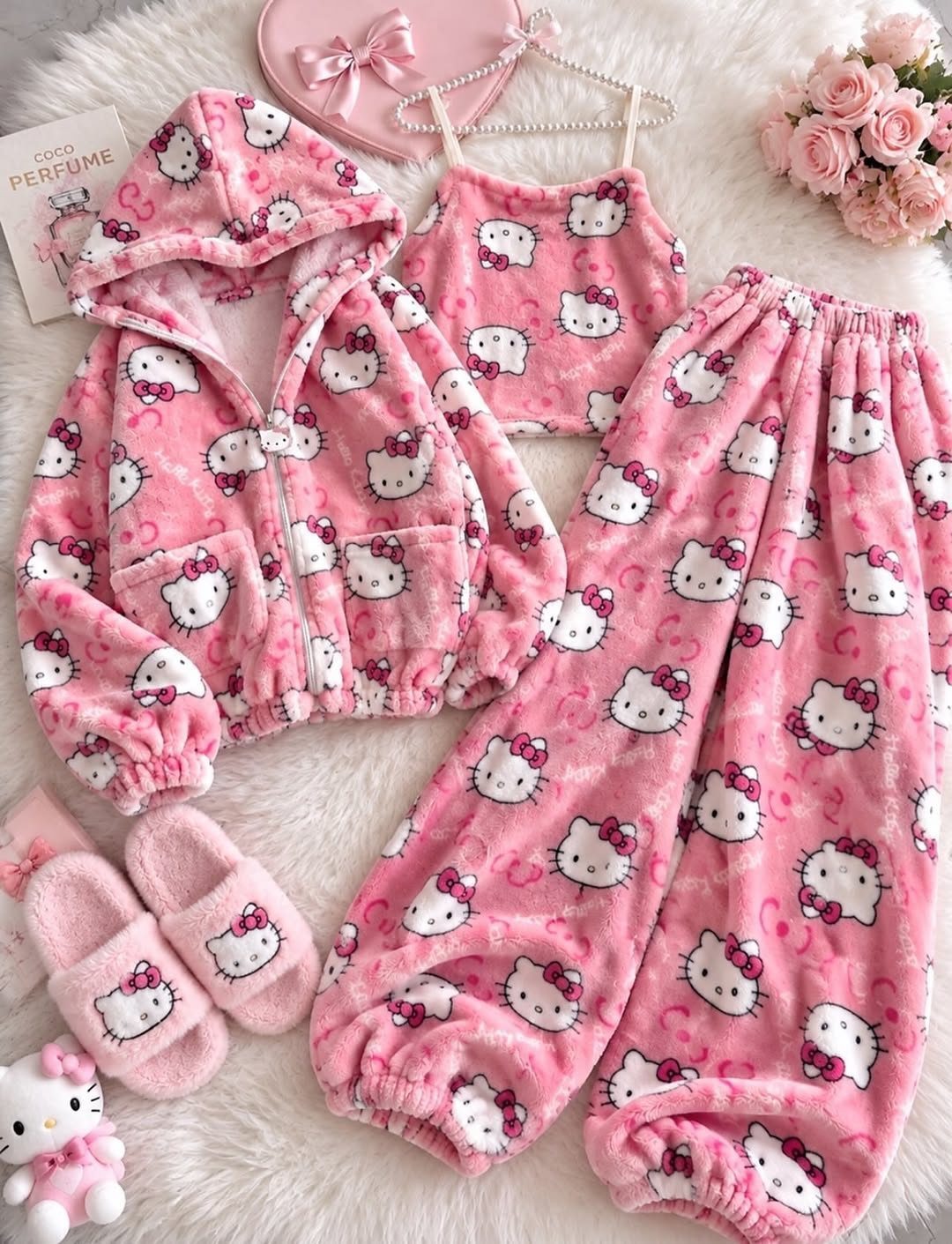 Pink plush Hello Kitty pajama set with matching slippers on white faux-fur background.