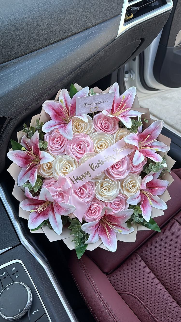 Bouquet of pink and white roses and lilies on a car seat