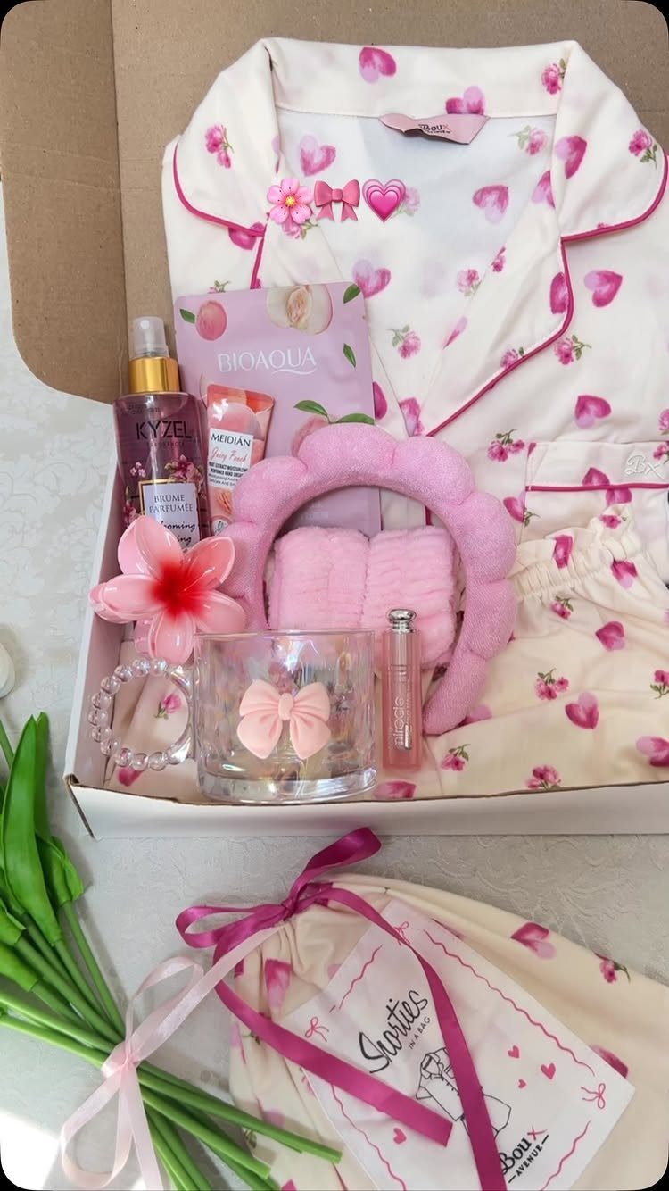 White floral pajama set and pink self-care products arranged in a gift box.
