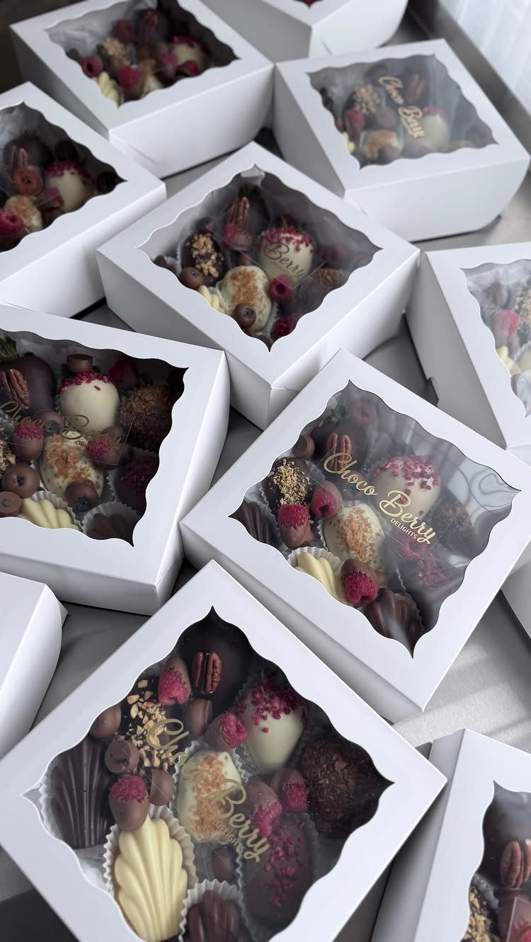 Chocolate covered strawberries and truffles in white gift boxes with clear windows