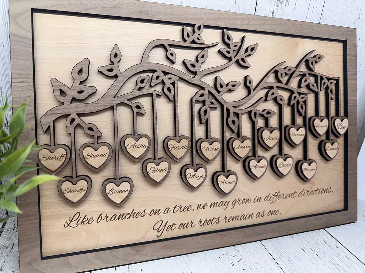 Wooden family tree sign with hanging heart tags and an engraved quote.