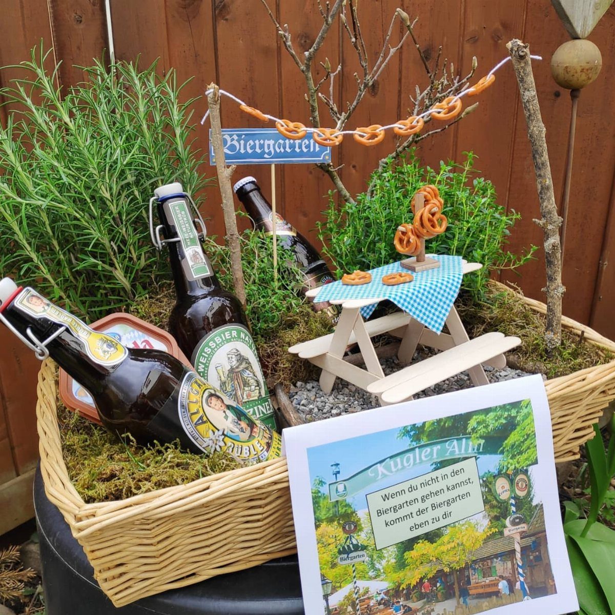 Miniature beer garden in a wicker basket with beer bottles and tiny pretzels.