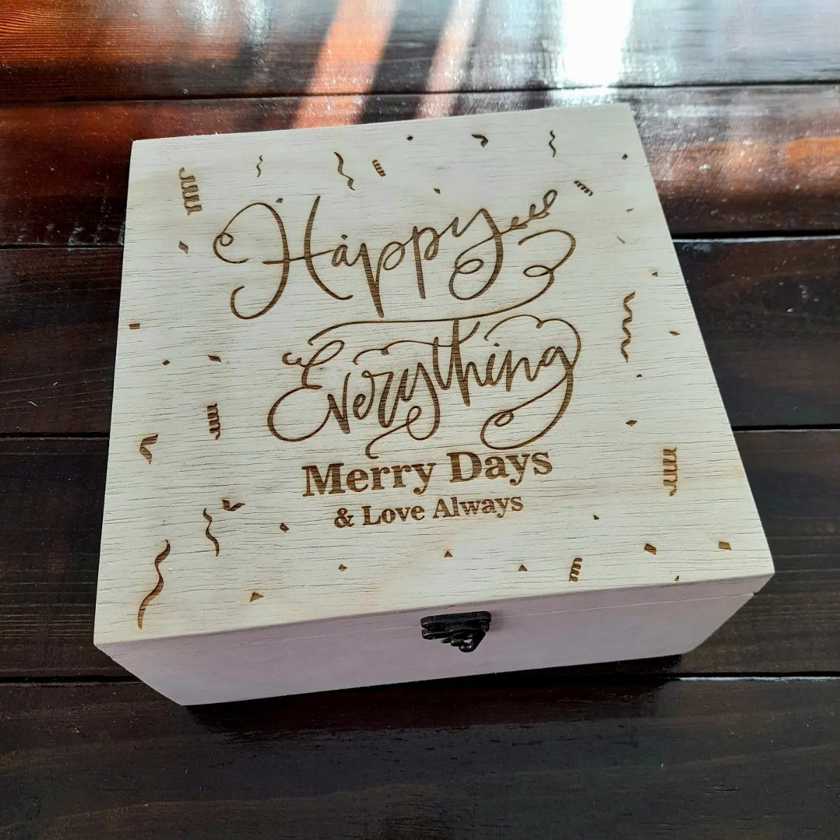 Engraved wooden gift box with Happy Everything text on a dark wood table