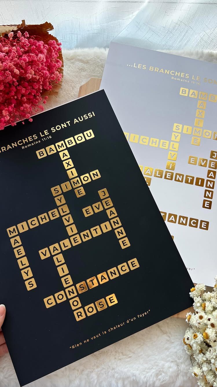 Crossword wall art with gold names on black and white backgrounds near flowers.