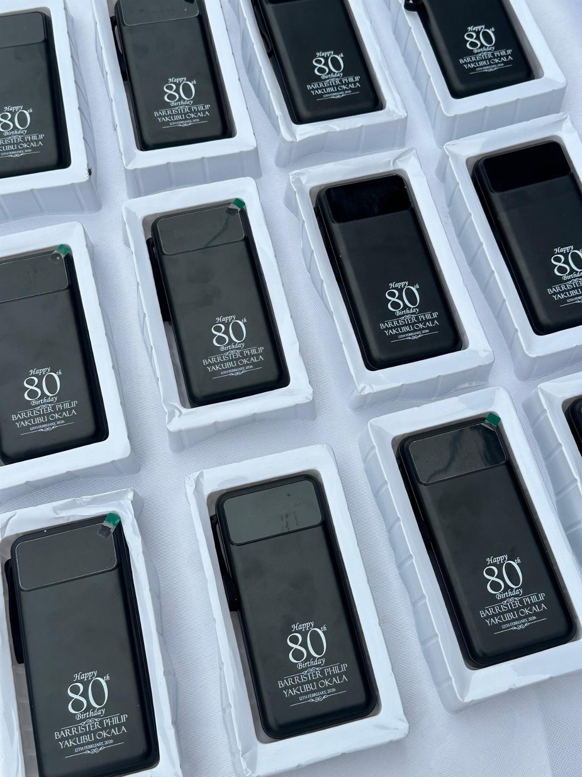 Black personalized lighters in white boxes celebrating a happy 80th birthday.