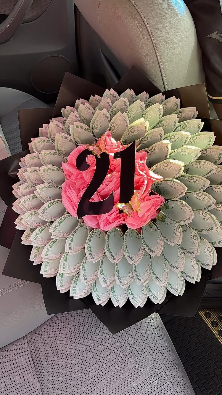Money bouquet with folded banknotes, pink flowers, and a black 21 topper.