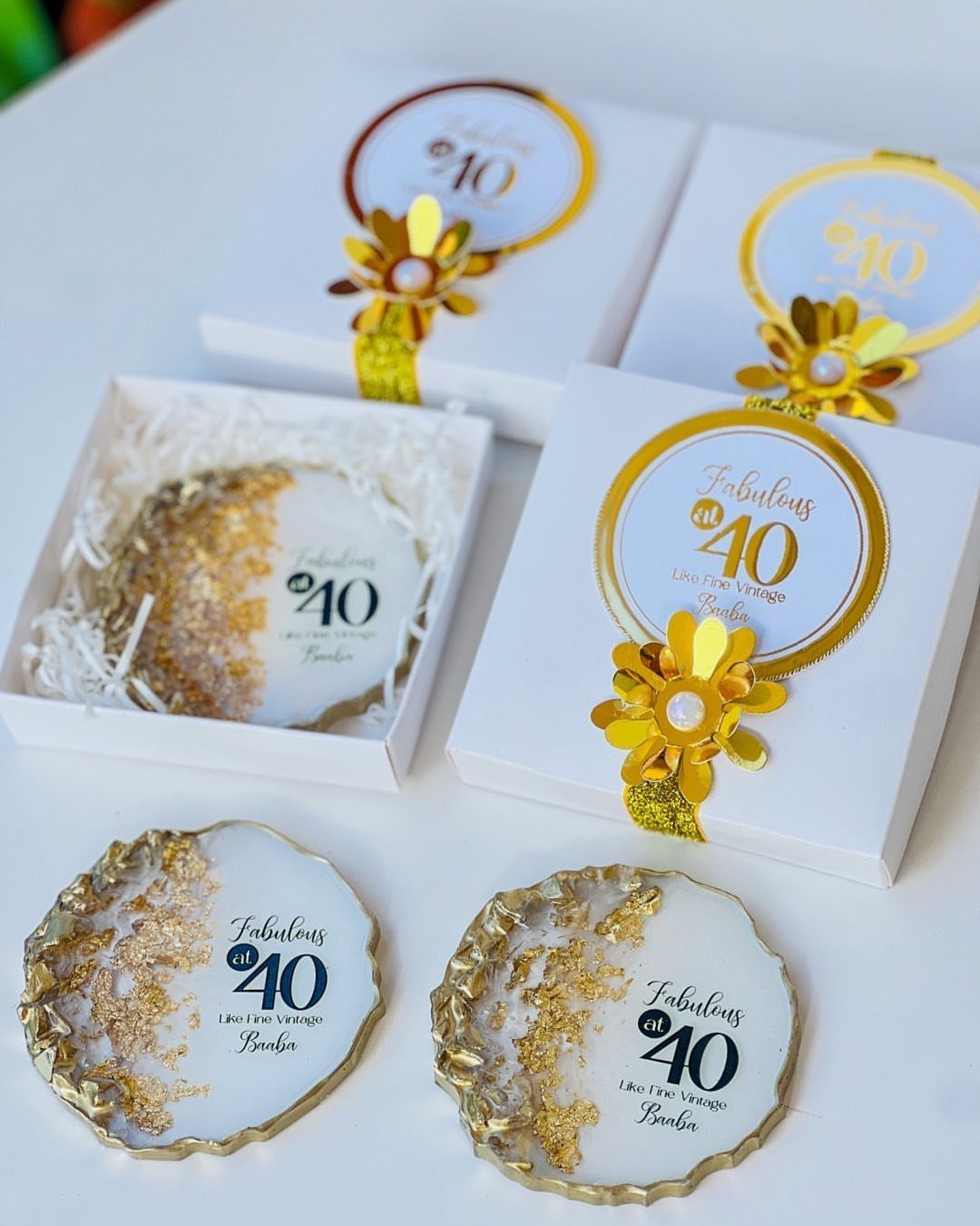 White gift boxes and gold-edged coasters featuring Fabulous at 40 birthday text.
