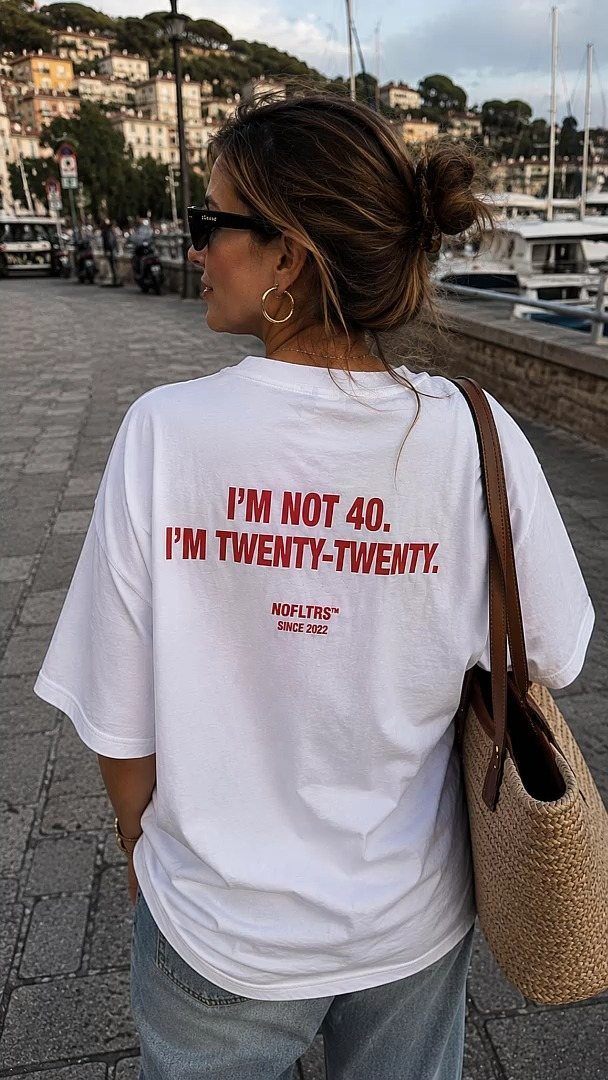 Woman wearing a white t-shirt with a funny 40th birthday quote in red text.