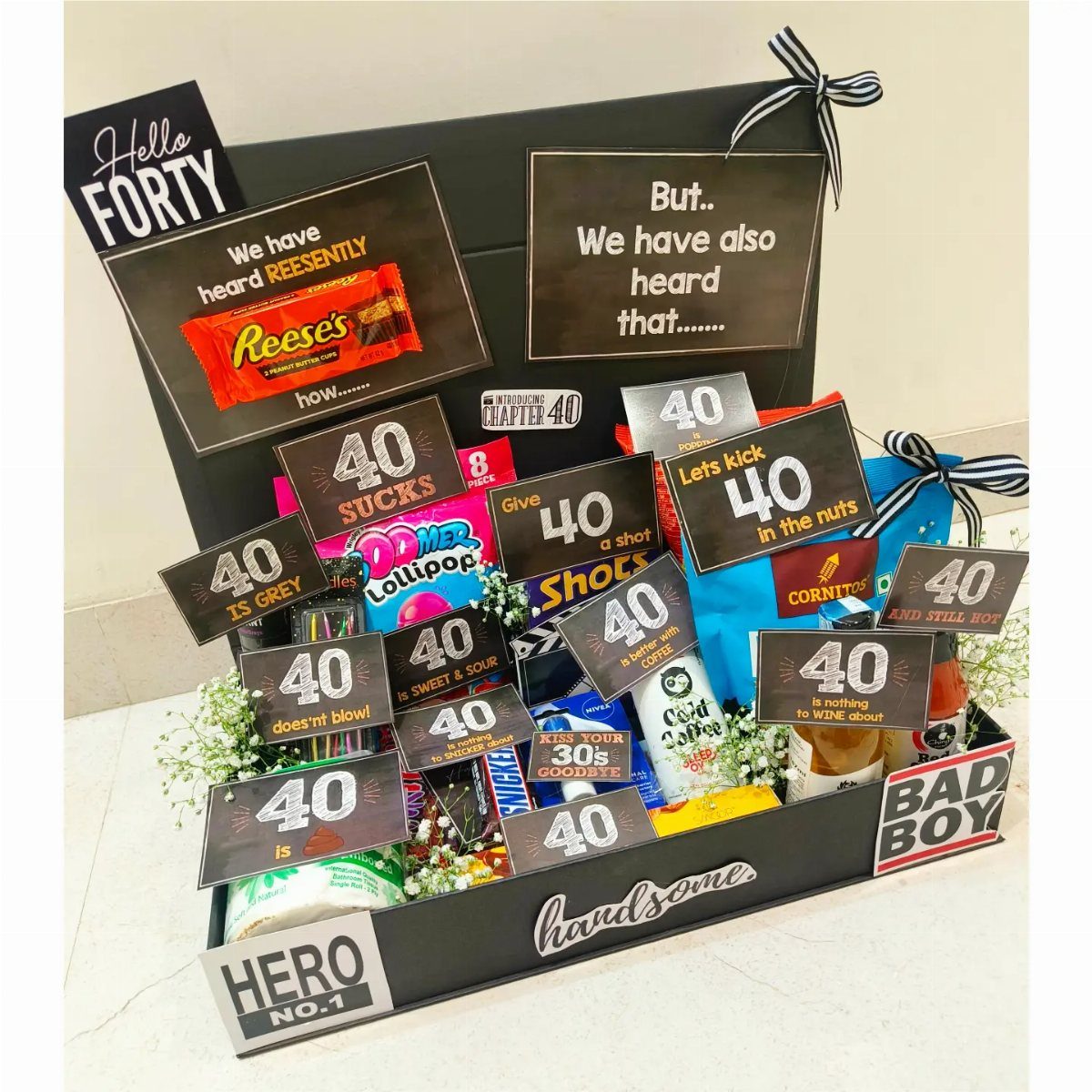 Black gift box filled with snacks and 40th birthday themed cards and messages.